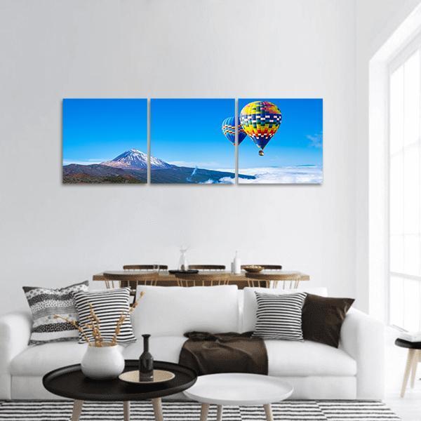 Hot Air Balloons Over Snow-capped Peak in Spain Panoramic Canvas Wall Art in white and blue, hung on a wall