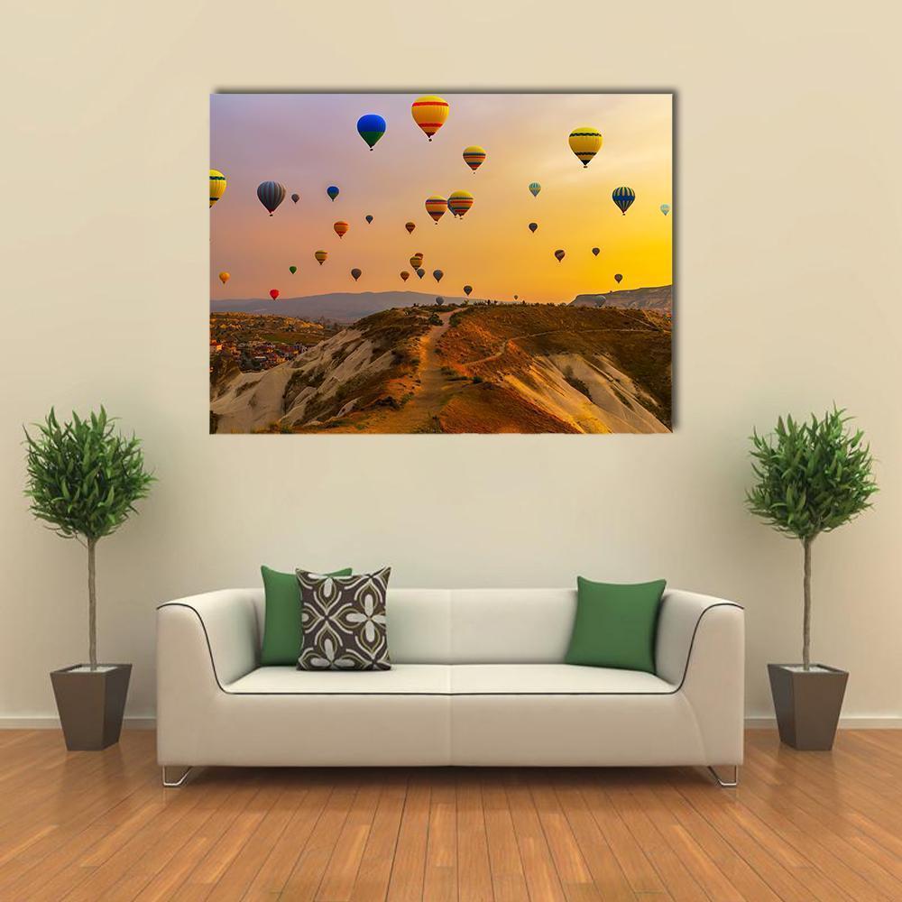Sunrise Hot Air Balloons Over Valley Canvas Wall Art in brown, orange and yellow, single panel hung on a wall