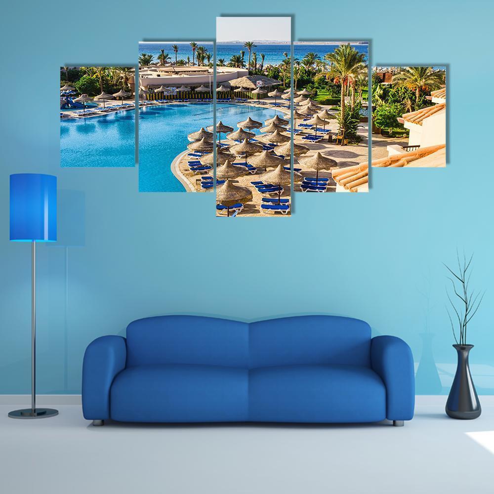 Aerial View of Hotel Pool in Egypt Canvas Wall Art in beige, green and blue, 5 panel Star layout hung on a wall