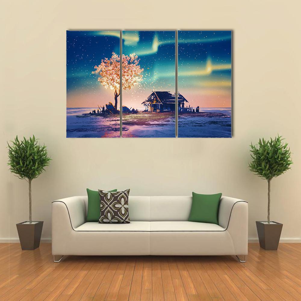 Weathered Hut with Glowing Tree Under Northern Lights Canvas Wall Art in yellow, blue and pink, 3 panel horizontal set hung on a wall