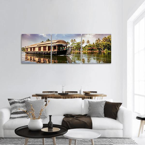 Thatched Houseboat with Palm Reflections Panoramic Canvas Wall Art in brown, green and blue, hung on a wall