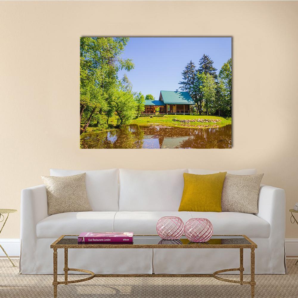 Countryside Cabin by Lake Canvas Wall Art in brown, green and blue, single panel hung on a wall
