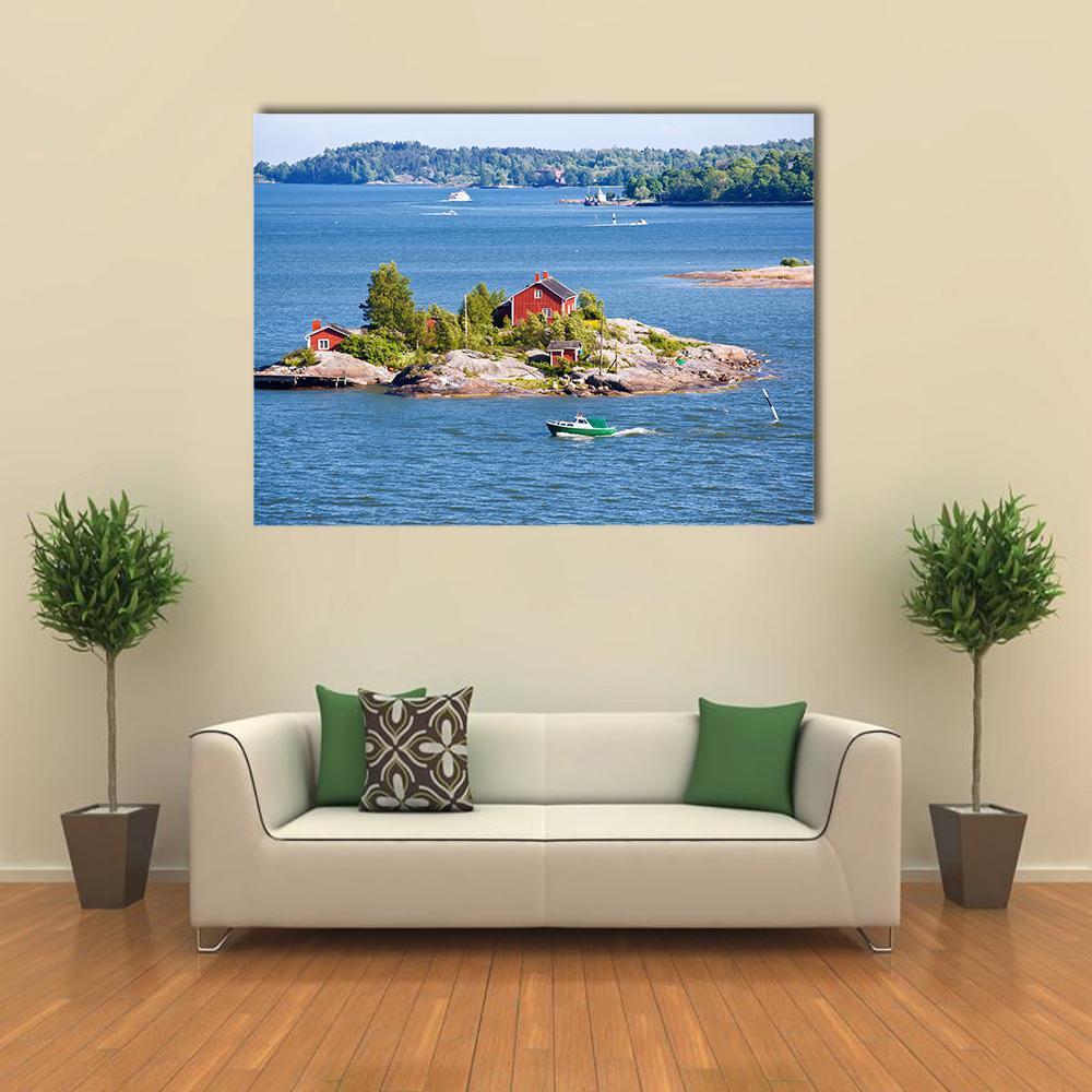 Red Cottages on Rocky Island Canvas Wall Art in red, green and blue, single panel hung on a wall