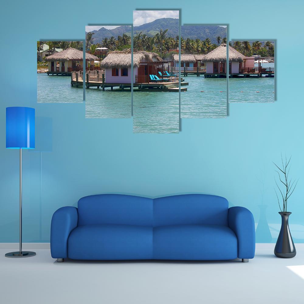Amber Light Overwater Bungalows Canvas Wall Art in gray, brown and blue, 5 panel Star layout hung on a wall
