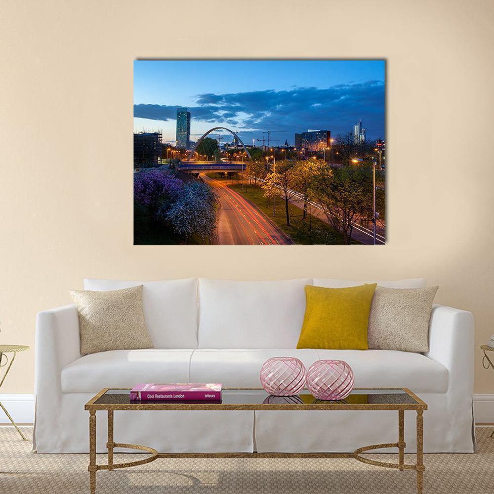Hulme Arch Bridge Light Trails Canvas Wall Art in black, orange and blue, single panel hung on a wall