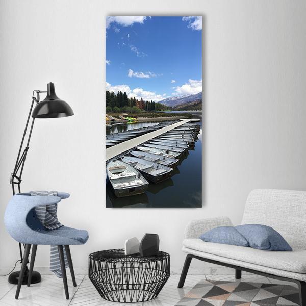 Rowboats Docked at Mountain Lake Vertical Canvas Wall Art in white, gray and blue, single vertical panel hung on a wall