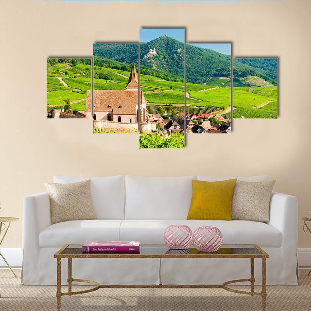 Hunawihr Village with Vineyard and Church Canvas Wall Art in green and blue, 5 panel Star layout hung on a wall