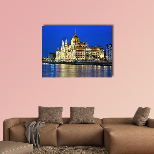 Illuminated Hungarian Parliament Building at Night Canvas Wall Art in gold, yellow and blue, single panel hung on a wall