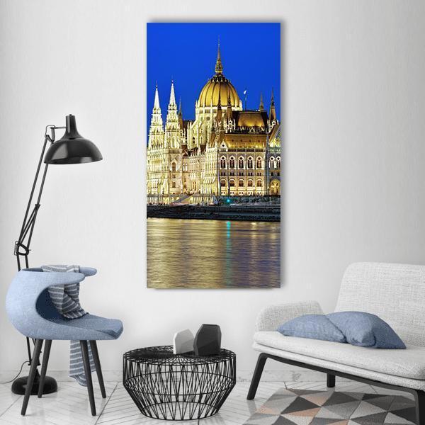 Hungarian Parliament Building at Night Vertical Canvas Wall Art in gold, yellow and blue, single vertical panel hung on a wall
