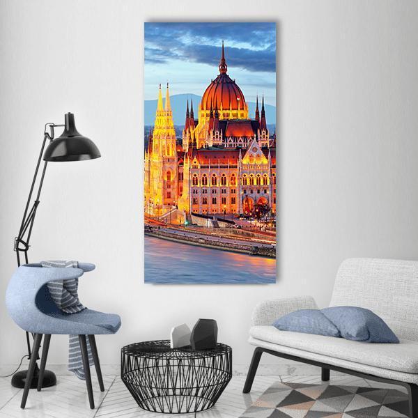 Hungarian Parliament Building at Dusk Vertical Canvas Wall Art in orange, yellow and blue, single vertical panel hung on a wall