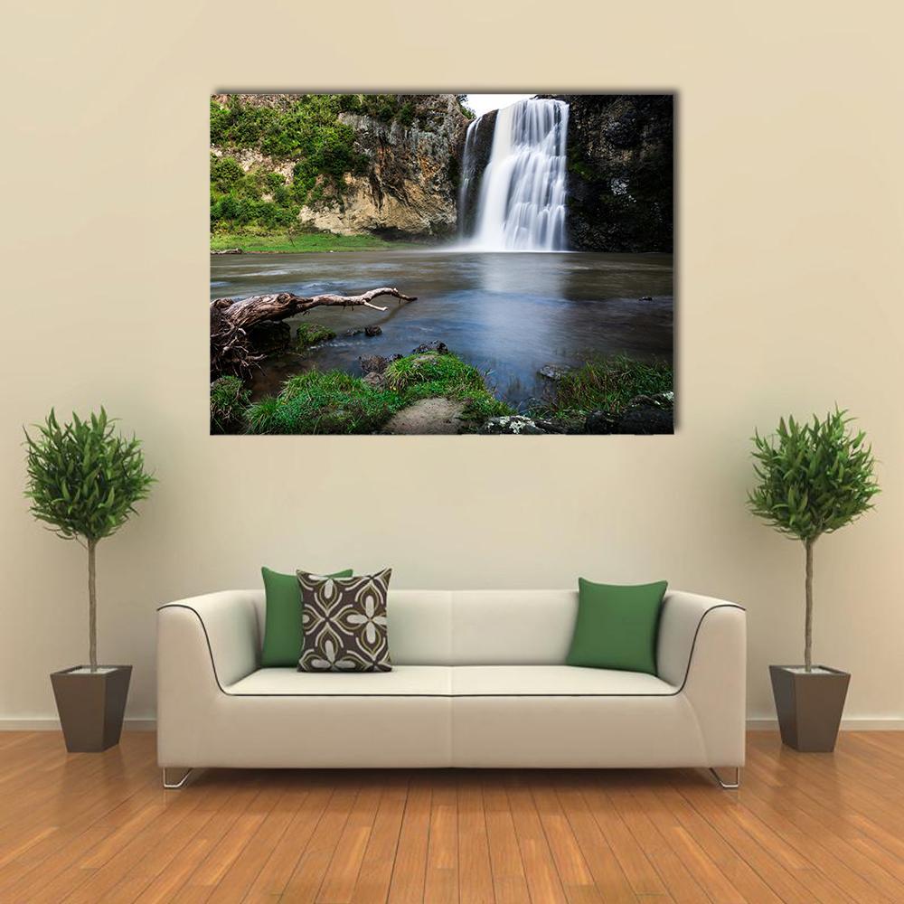 Hunua Waterfall with Fallen Log Canvas Wall Art in brown, green and blue, single panel hung on a wall