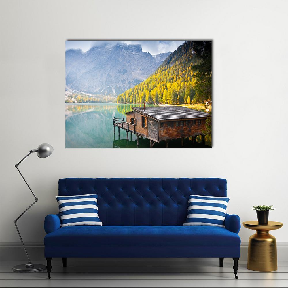 Wooden Boathouse on Mountain Lake Canvas Wall Art in brown, yellow and blue, single panel hung on a wall