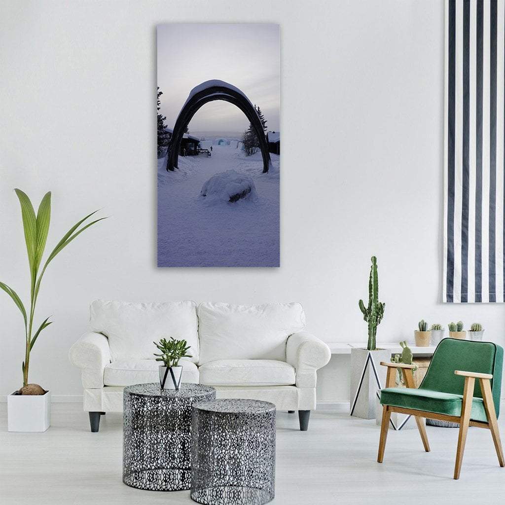 Whalebone Arch Framing Winter Village Vertical Canvas Wall Art in white, gray and blue, single vertical panel hung on a wall