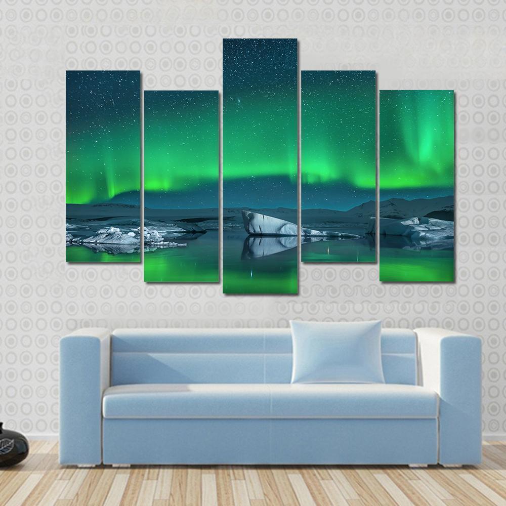 Icebergs Under Northern Lights Canvas Wall Art in green, blue and navy, 5 panel Star layout hung on a wall