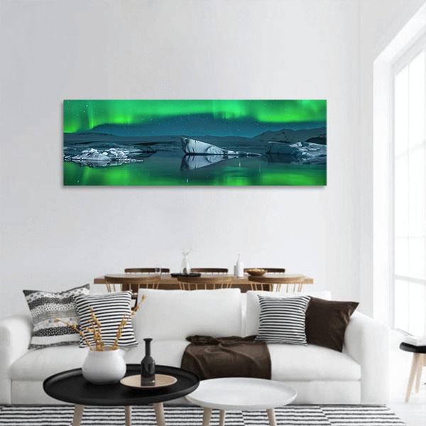 Icebergs Under Northern Lights Panoramic Canvas Wall Art in green and blue, hung on a wall