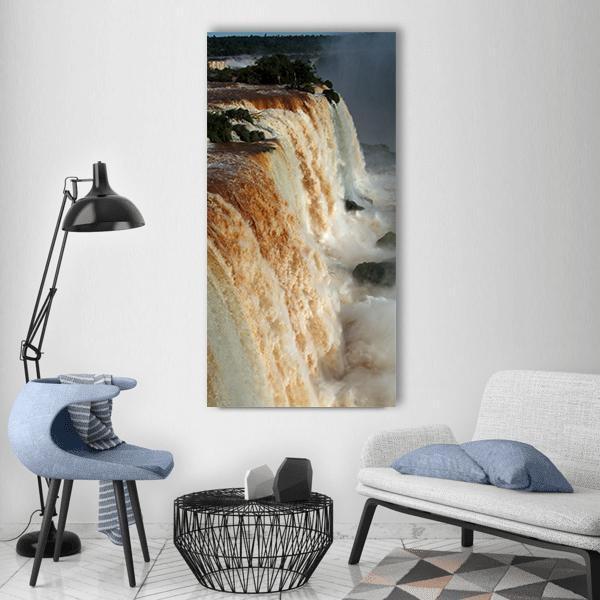 Iguazu Falls with Brown Water and Mist Vertical Canvas Wall Art in white, beige and brown, single vertical panel hung on a wall