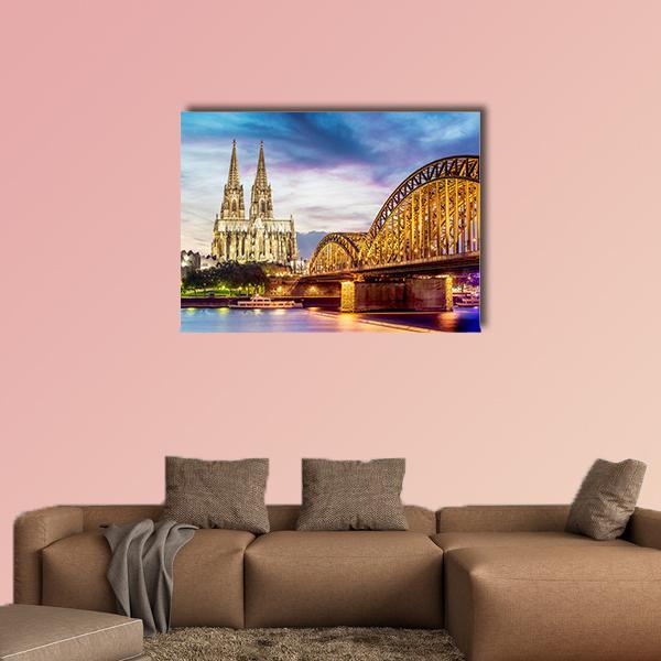Cologne Cathedral and Hohenzollern Bridge Canvas Wall Art in gold, blue and purple, single panel hung on a wall
