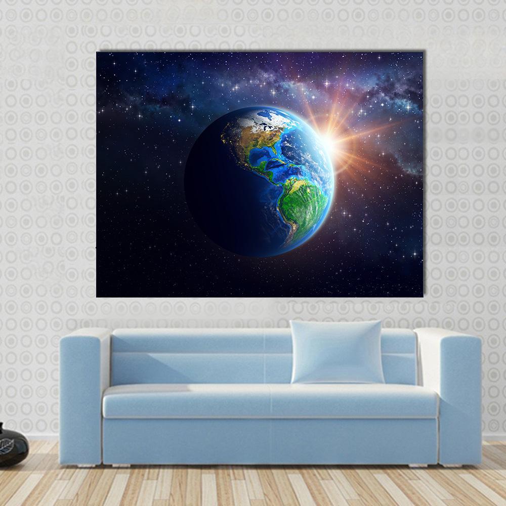 Illuminated Face of Earth Canvas Wall Art in black, gold and blue, single panel hung on a wall