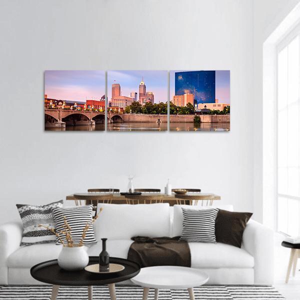 Indianapolis Skyline at Sunset Panoramic Canvas Wall Art in orange, blue and pink, hung on a wall