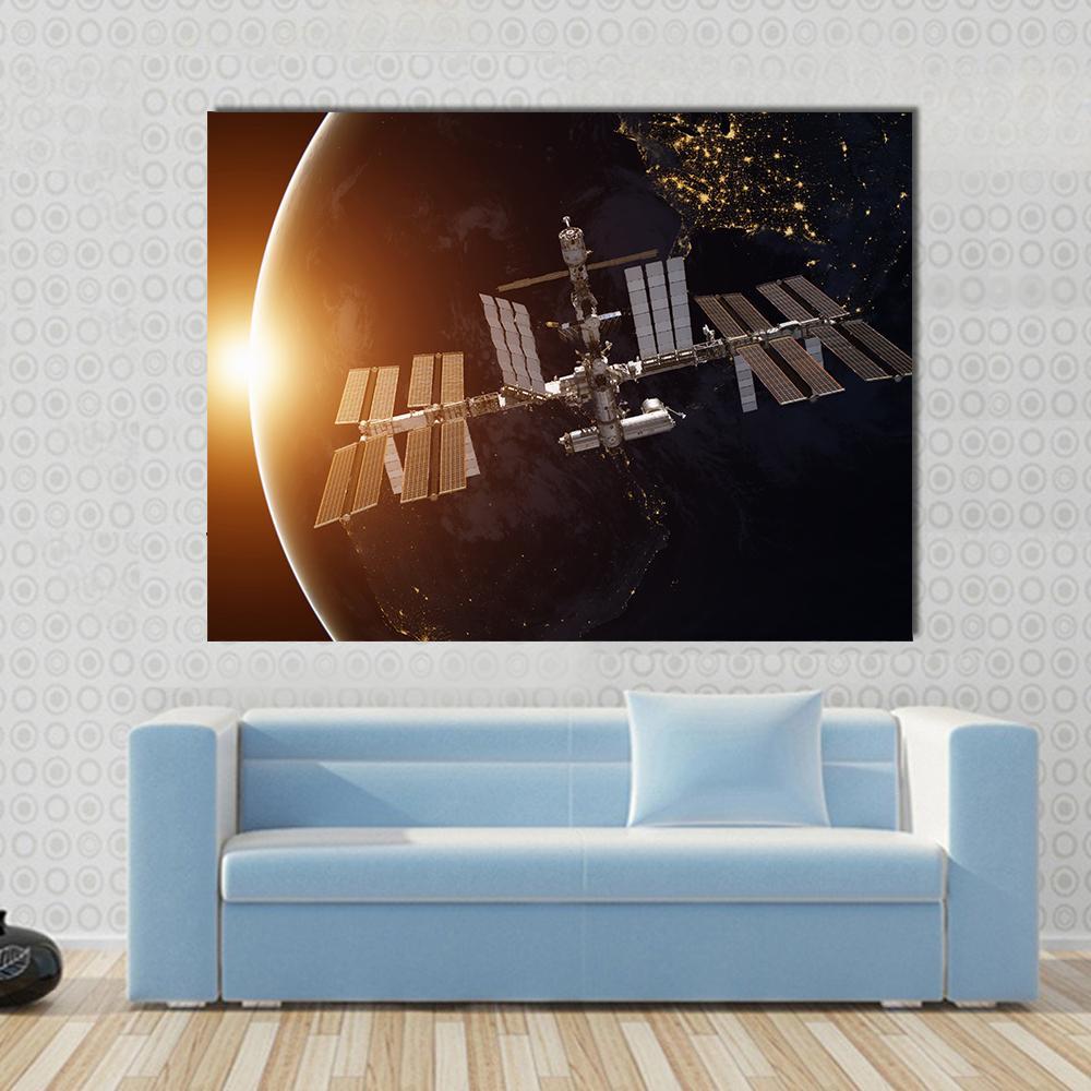 International Space Station Over Planet Earth Canvas Wall Art in black, white and orange, single panel hung on a wall