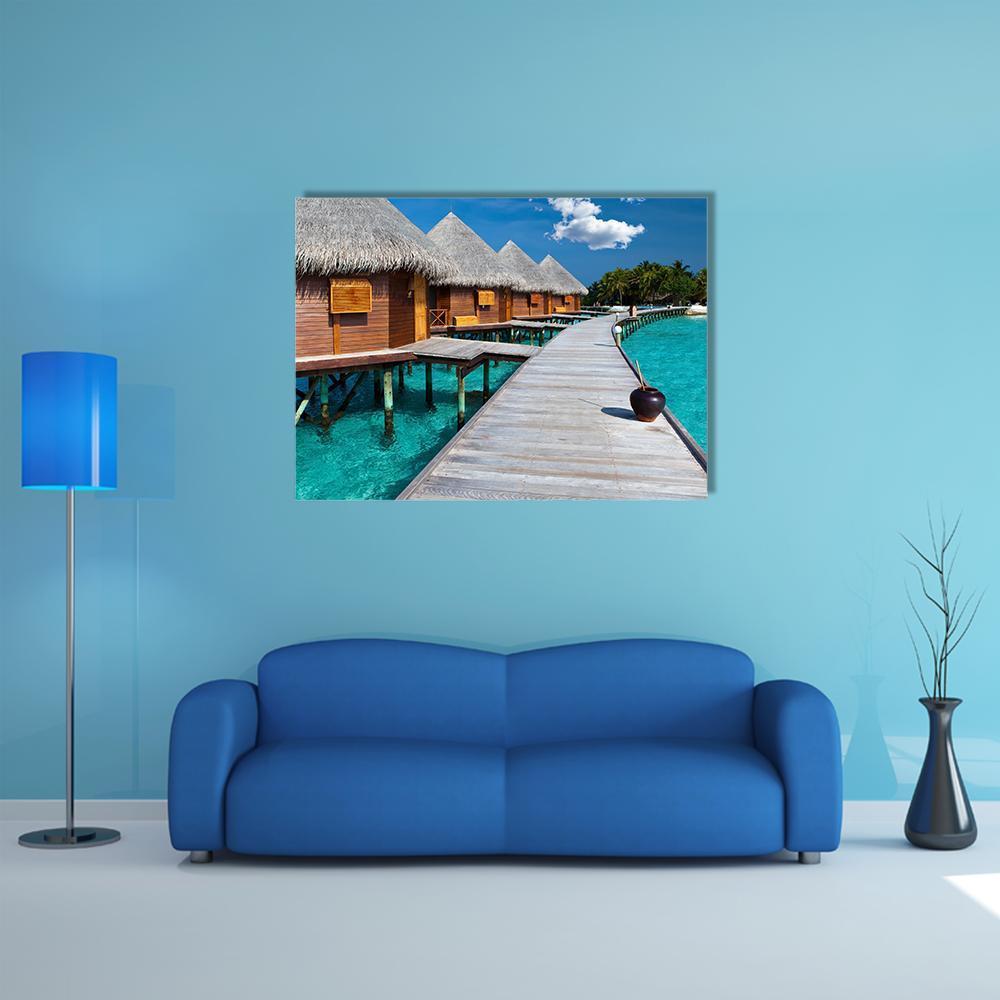 Maldives Overwater Bungalows and Pier Canvas Wall Art in brown and blue, single panel hung on a wall