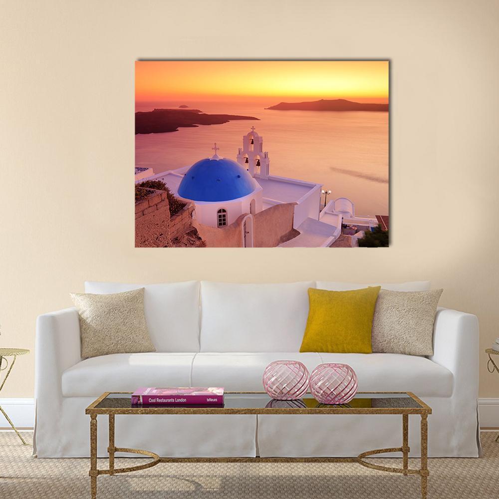 Santorini Church and Sunset Over Ocean Canvas Wall Art in orange, yellow and blue, single panel hung on a wall