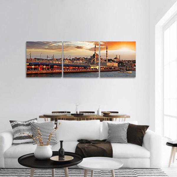 Istanbul Sunset Over Galata Bridge Panoramic Canvas Wall Art in orange, yellow and blue, hung on a wall