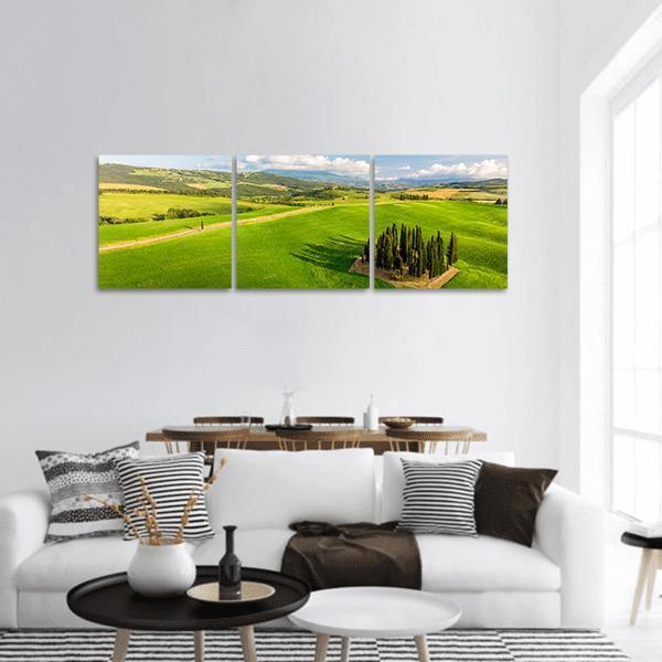 Italian Cypresses in Tuscany Panoramic Canvas Wall Art in yellow, green and blue, hung on a wall