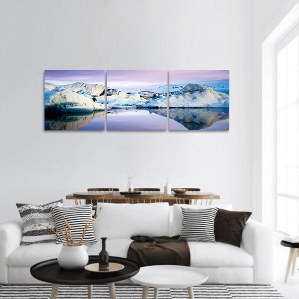 Jokulsarlon Glacier Lagoon Icebergs and Reflection Panoramic Canvas Wall Art in white and blue, hung on a wall