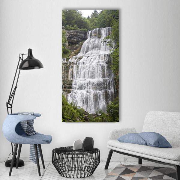 Tiered Forest Waterfall with Lush Foliage Vertical Canvas Wall Art in white, gray and green, single vertical panel hung on a wall
