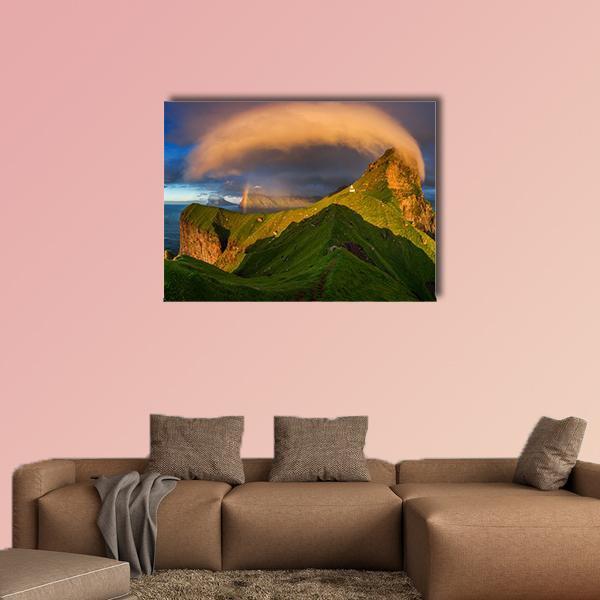 Faroe Cliffs with Lighthouse and Rainbow Canvas Wall Art in orange, green and blue, single panel hung on a wall