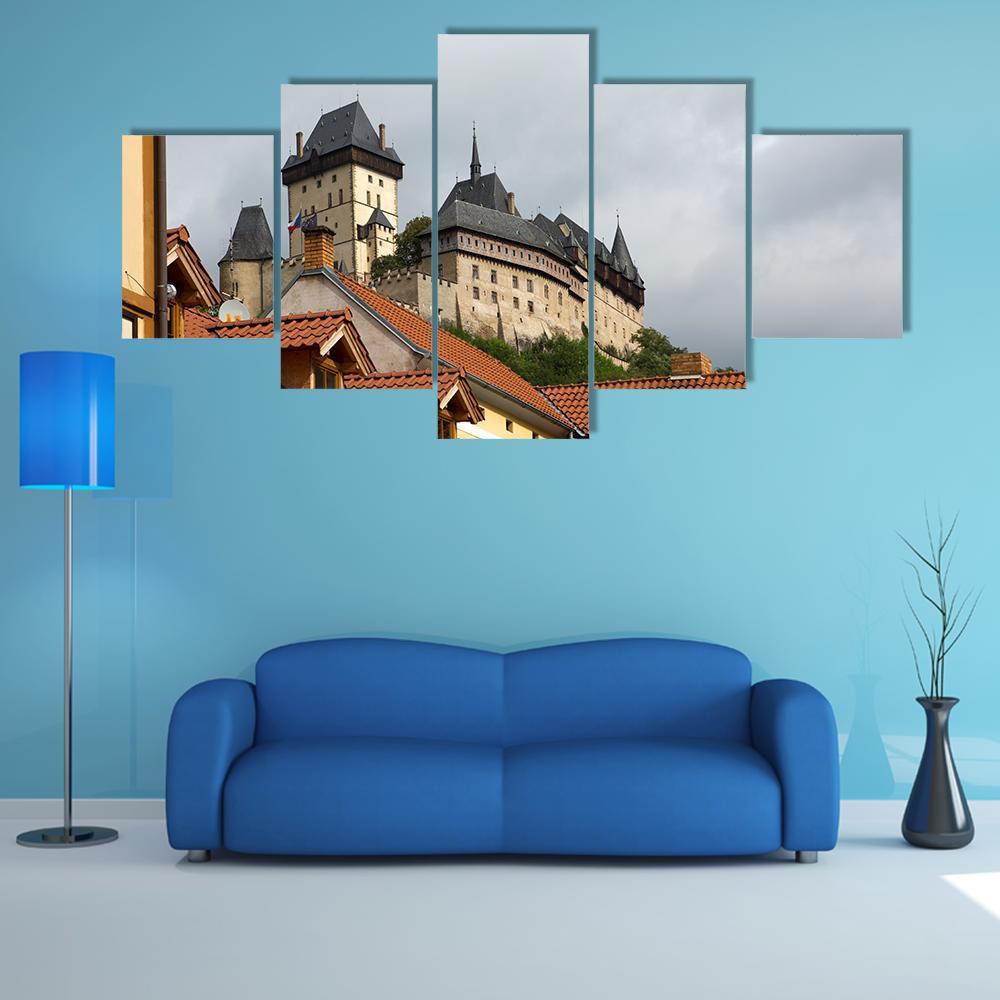 Karlstejn Medieval Castle Over Rooftops Canvas Wall Art in gray, brown and orange, 5 panel Star layout hung on a wall