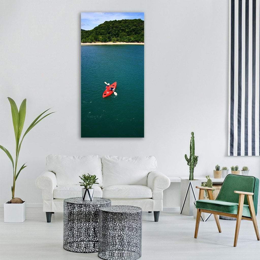 Aerial Red Kayak Over Tropical Beach Vertical Canvas Wall Art in red, green and blue, single vertical panel hung on a wall