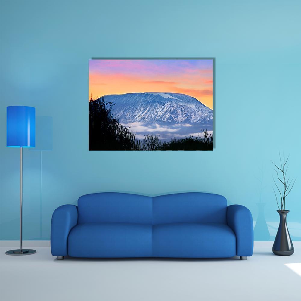 Kilimanjaro at Sunrise Canvas Wall Art in orange, blue and purple, single panel hung on a wall
