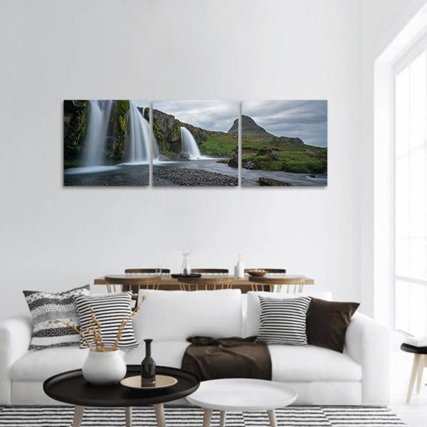 Cloudy Day Waterfall and Conical Peak Panoramic Canvas Wall Art in gray, green and blue, hung on a wall
