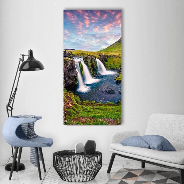 Kirkjufellsfoss Waterfall Vertical Canvas Wall Art in green, blue and pink, single vertical panel hung on a wall