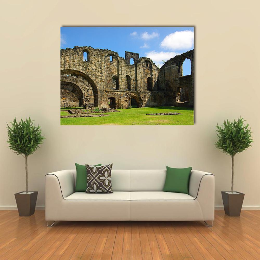 Kirkstall Abbey Ruins Canvas Wall Art in brown, green and blue, single panel hung on a wall