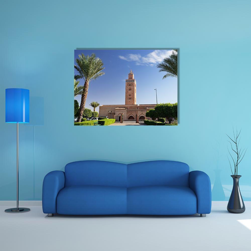 Koutoubia Mosque Minaret Under Blue Sky Canvas Wall Art in beige, green and blue, single panel hung on a wall