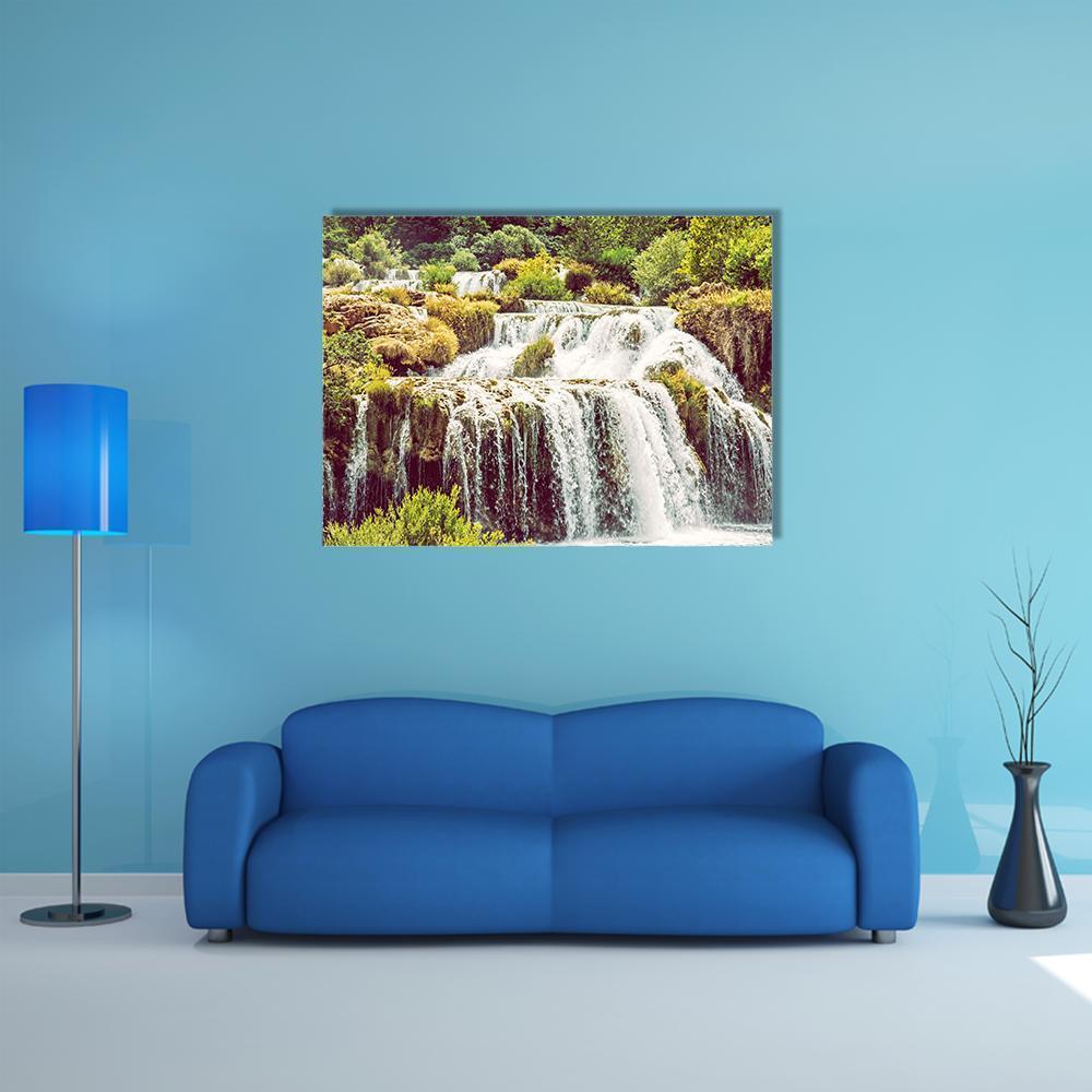 Krka Waterfalls Over Rocks and Lush Greenery Canvas Wall Art in white, brown and green, single panel hung on a wall