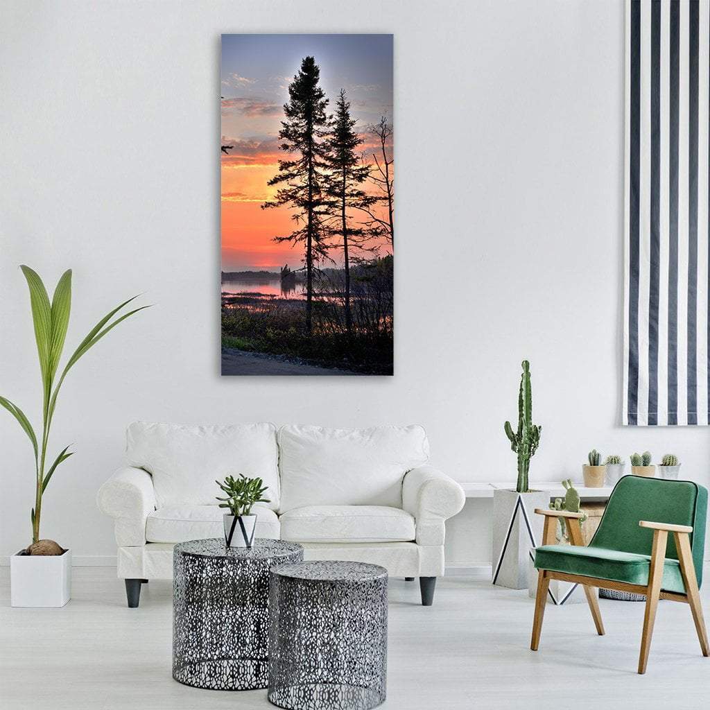 Twilight Lake with Silhouetted Trees Vertical Canvas Wall Art in black, orange and blue, single vertical panel hung on a wall