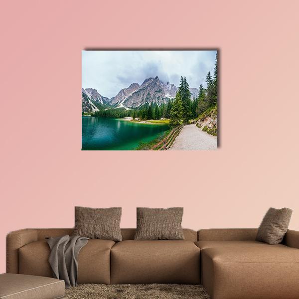 Snow-capped Mountain Lake with Pine Path Canvas Wall Art in gray, green and blue, single panel hung on a wall