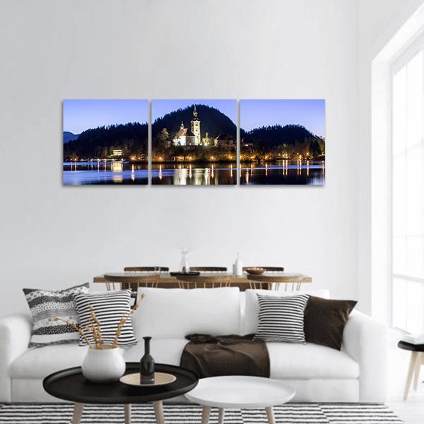 Church on Hill Above Reflective Lake Panoramic Canvas Wall Art in black, white and blue, hung on a wall