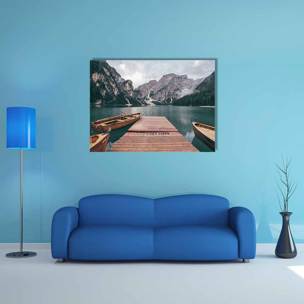 Wooden Rowboats on Lake Braies Canvas Wall Art in gray, brown and blue, single panel hung on a wall