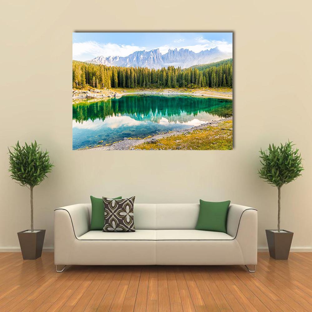 Lake Carezza Mountain Reflection Canvas Wall Art in yellow, green and blue, single panel hung on a wall