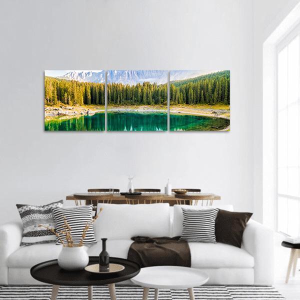 Lake Carezza Reflection Panoramic Canvas Wall Art in yellow, green and blue, hung on a wall
