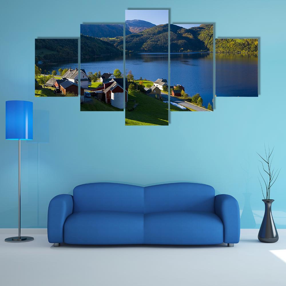 Lake Village with Red and White Houses Canvas Wall Art in brown, green and blue, 5 panel Star layout hung on a wall