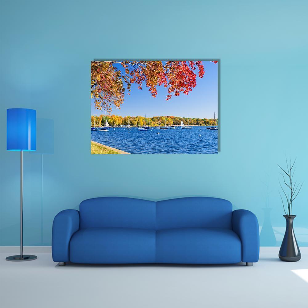 Autumn Lakeshore with Sailboats Canvas Wall Art in orange, yellow and blue, single panel hung on a wall