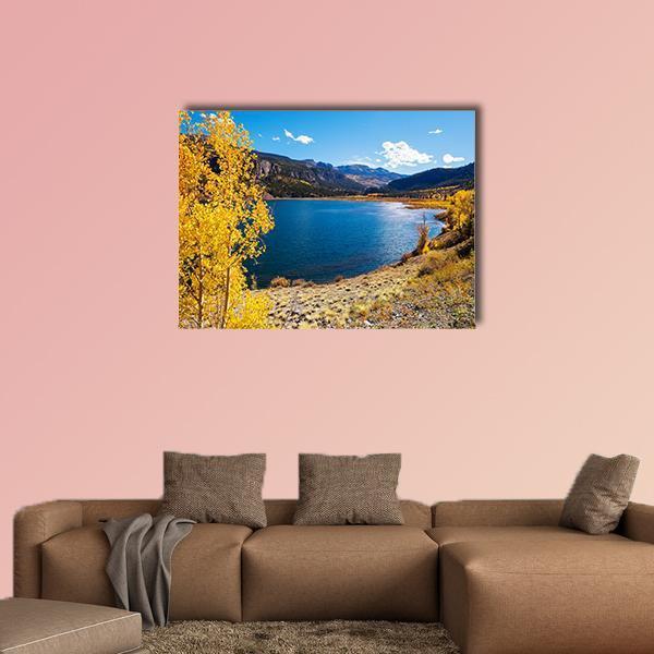 Autumn Lake with Yellow Foliage and Mountains Canvas Wall Art in brown, yellow and blue, single panel hung on a wall