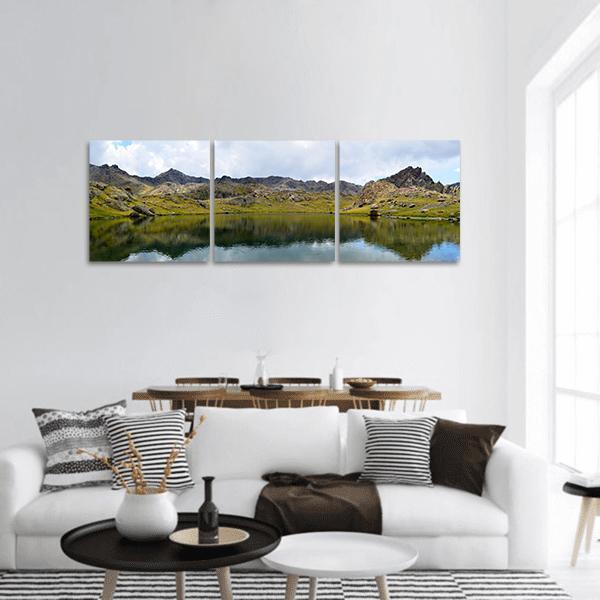 Alpine Lake with Mountain Reflections Panoramic Canvas Wall Art in gray, green and blue, hung on a wall