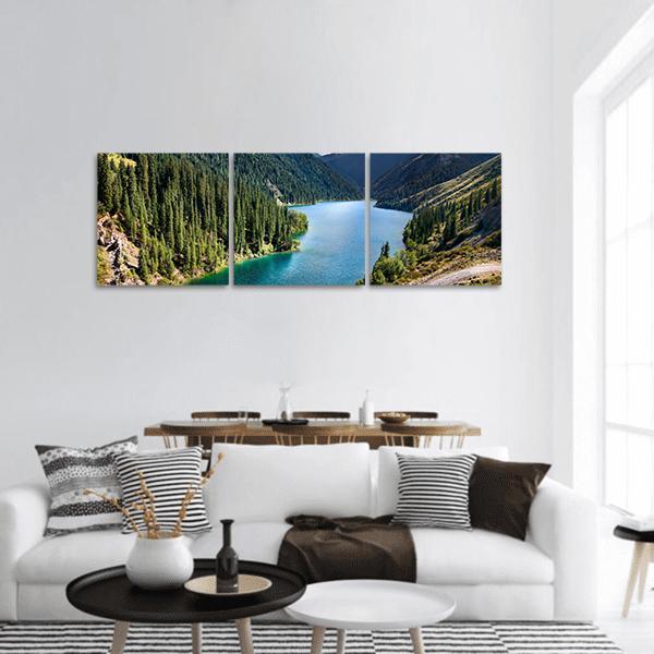 Lake Kolsai Alpine Lake View Panoramic Canvas Wall Art in green and blue, hung on a wall